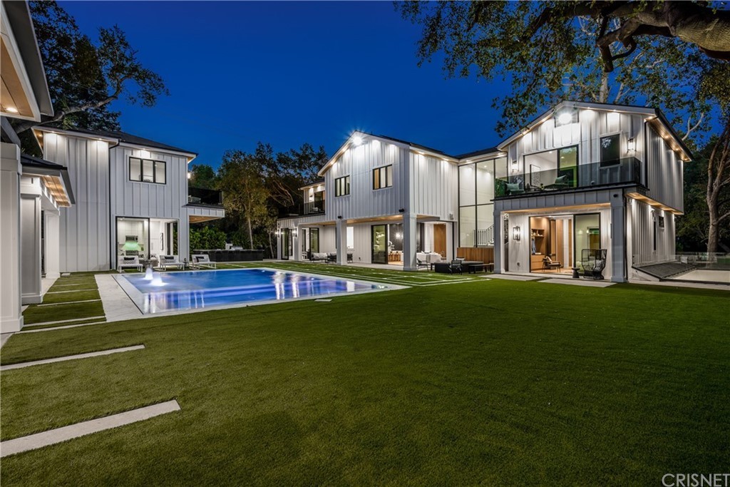 Well-lit luxury homes with a yard pool